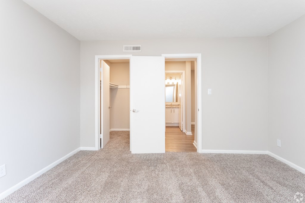 an empty living room with white walls and carpet at The Hudson, Fayetteville, North Carolina