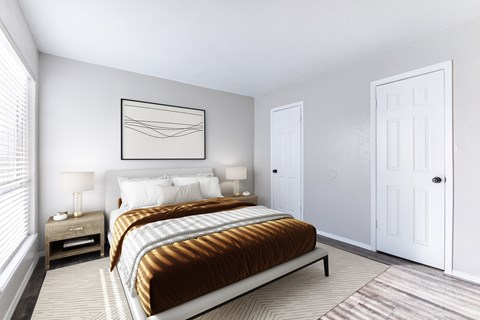 A bedroom with a large bed and a nightstand with a lamp.