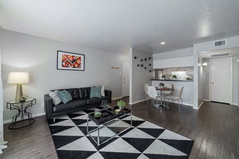 a living room with a checkered rug and a black couch