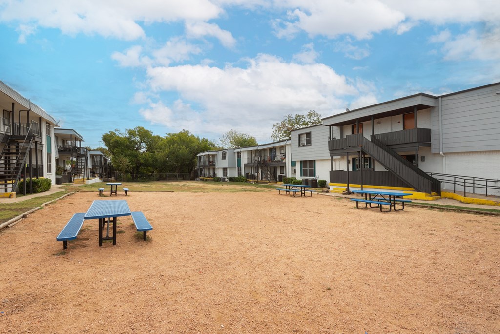 Community area with picnic tables and benches at Carisma, Dallas, 75240