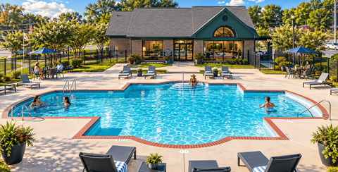A large outdoor swimming pool with people in it and a building in the background.