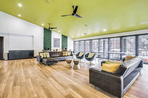 A spacious living room with a black couch and wooden floors.