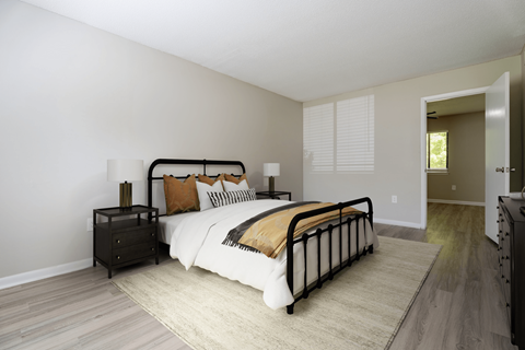 A bedroom with a large bed and a nightstand.