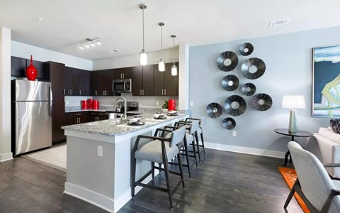 A modern kitchen with a large island and a dining table set for four.