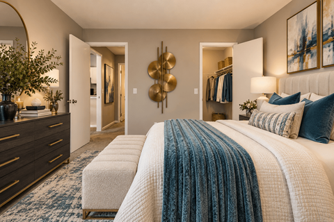 A bedroom with a large bed and a dresser with a plant on top.