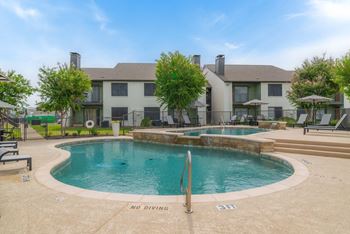 our apartments offer a swimming pool with a house in the background