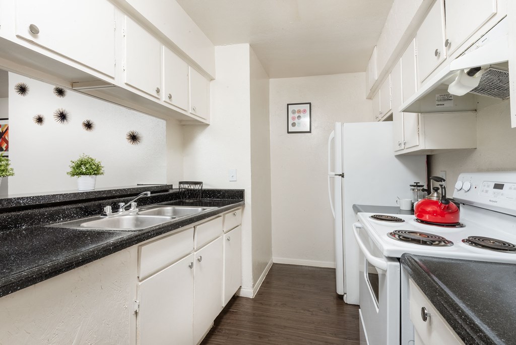 a kitchen with white appliances and black counter tops and white cabinets a kitchen with white appliances and black counter tops and white cabinets at Lumina, Dallas, 75240