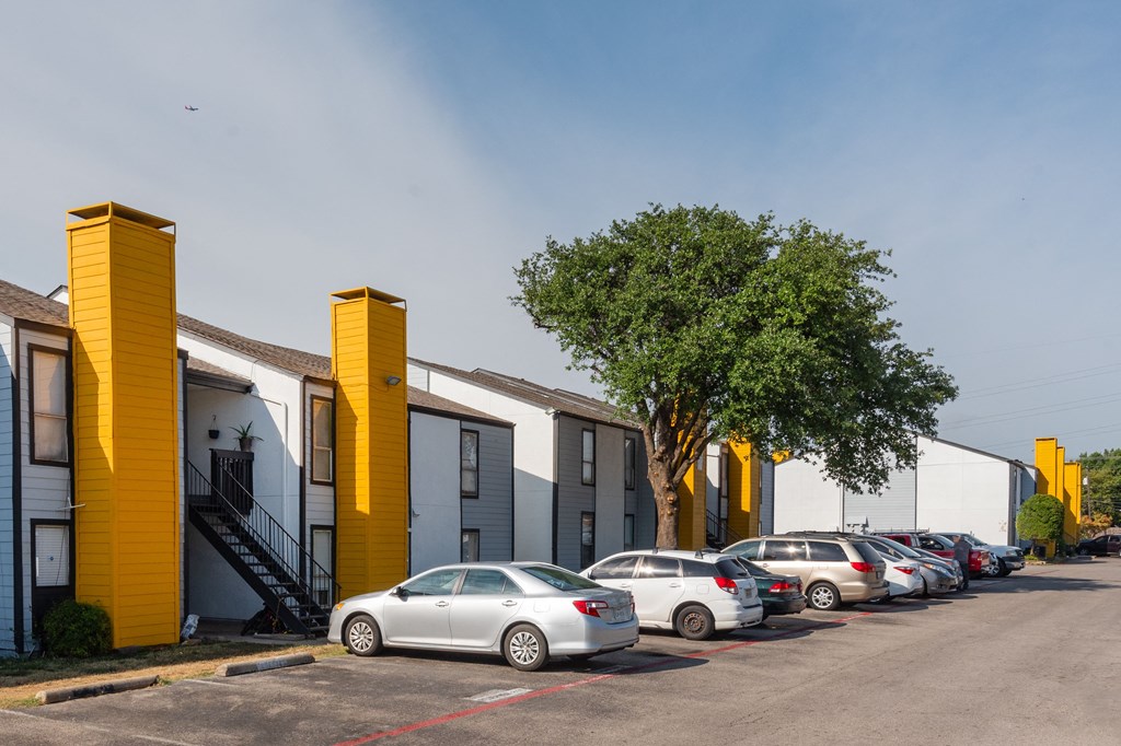 a row of houses with cars parked in front of them at Helios, Dallas, TX 75240