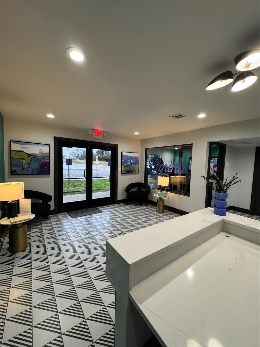 A black and white tiled lobby with a white reception desk.