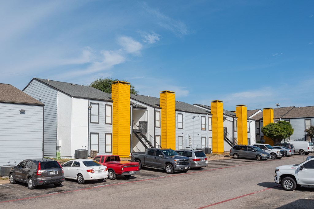 a row of houses with cars parked in front of them at Helios, Dallas, TX 75240