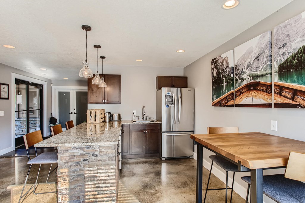 the kitchen and dining area of a house with a table and chairs