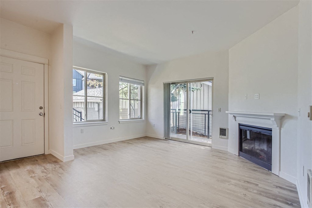 a living room with a fireplace and a door to a balcony