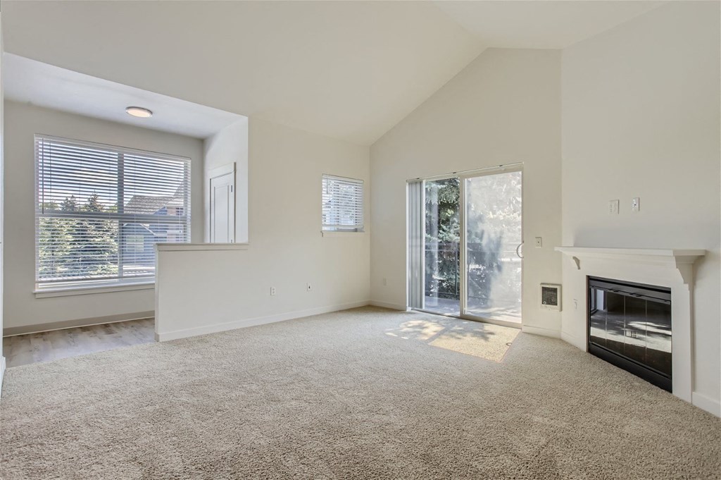an empty living room with a fireplace and a window