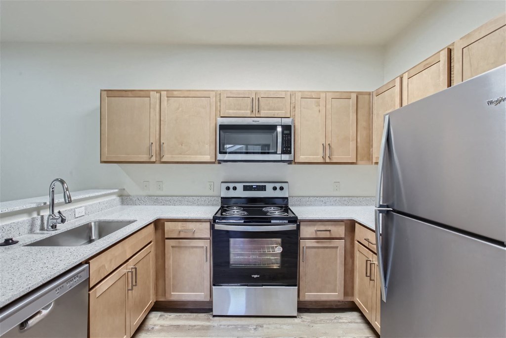 a kitchen with stainless steel appliances and wooden cabinets