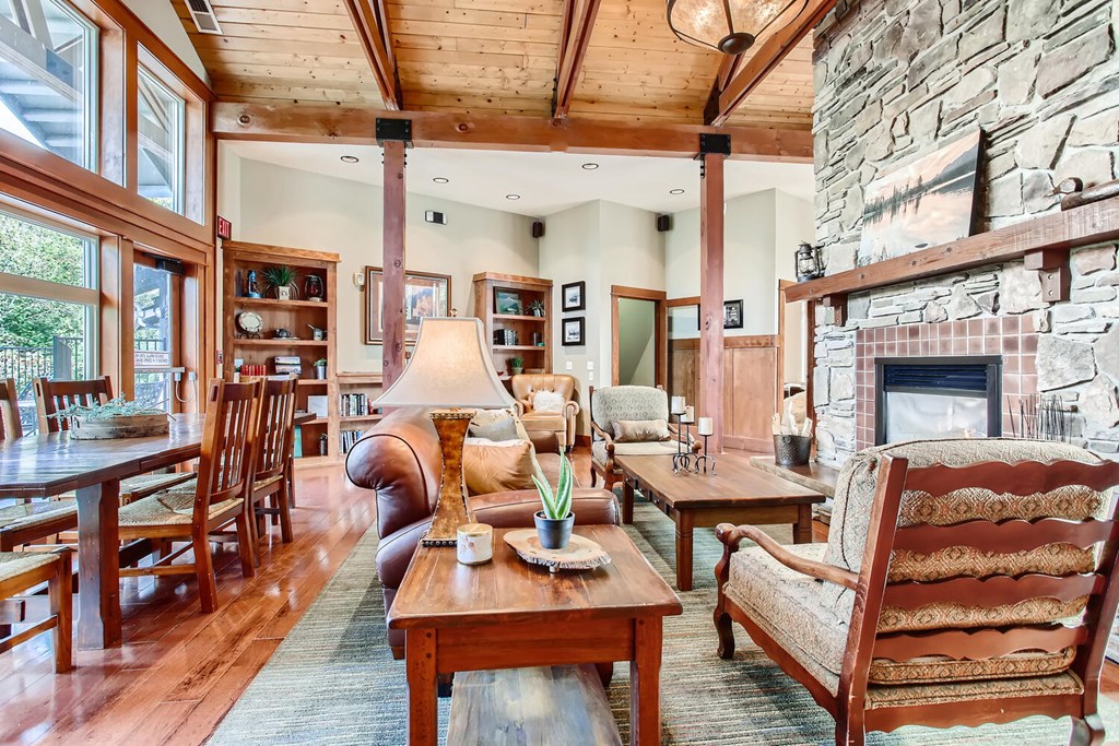 a large living room with a stone fireplace and wooden furniture