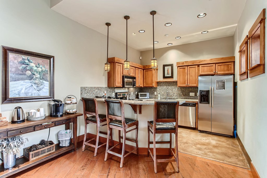 a kitchen with a bar and a refrigerator