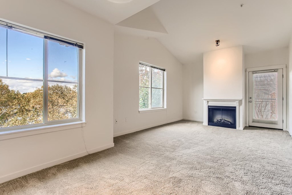 a living room with a fireplace and a large window