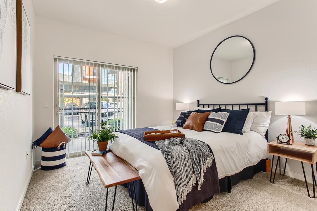 Fairview Apartments for Rent - Lodges at Lake Salish - Bedroom with Bed, Nightstands, Lamps, and Sliding Glass Door