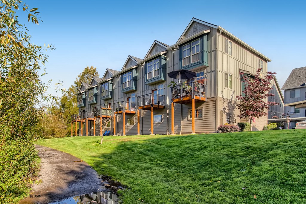 a row of houses with balconies overlooking a grassy field