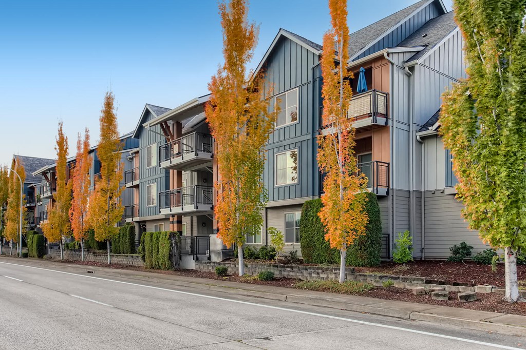a row of apartment buildings on the side of a street