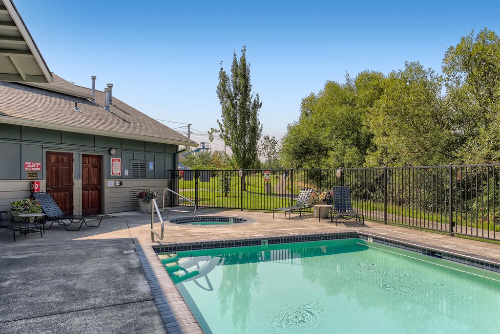 Apartments for Rent in Fairview-Lodges at Lake Salish-Gated Pool with Lounge Seating, Tables, and a Spa