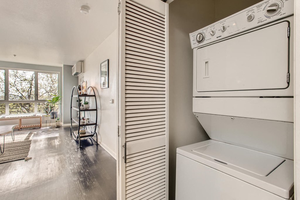 a laundry room with a washer and dryer and a living room with