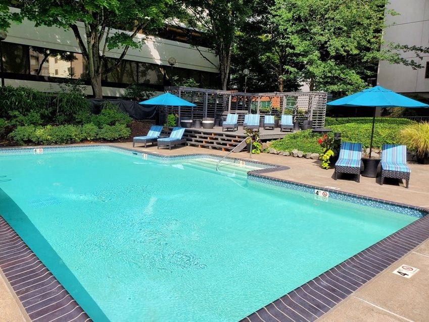 a large swimming pool with chairs and umbrellas