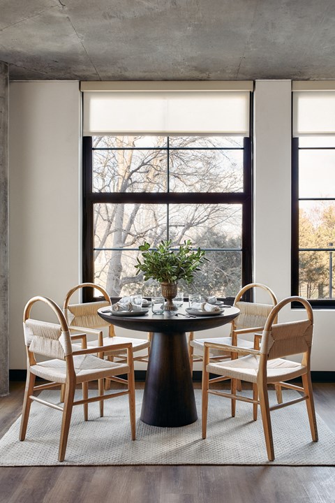 a dining room with a table and chairs and a window