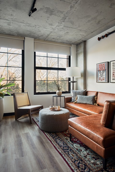 a living room with brown leather furniture and a rug