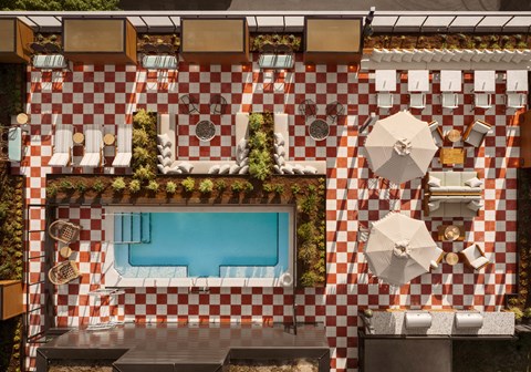 arial view of the pool area of a hotel with a swimming pool and tables
