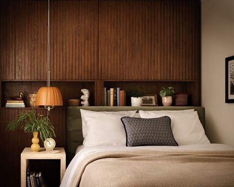 a bedroom with a bed with a wooden wall behind it