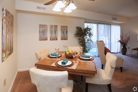 A dining room with a table set for a meal.