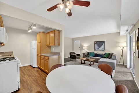 A living room with a white table and brown chairs.
