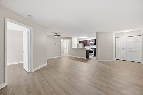 A spacious room with wooden flooring and white walls.