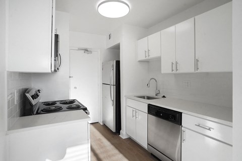 Kitchen with white cabinets, stainless steel appliances, and quarters countertop.