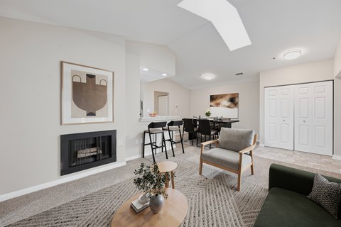 A living room with a fireplace and a dining table.