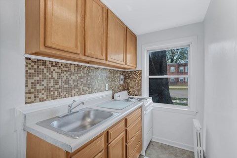 A kitchen with wooden cabinets and a tiled backsplash.