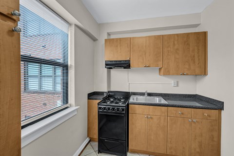 A kitchen with wooden cabinets and a black stove top oven.