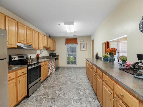 A kitchen with wooden cabinets and a marble floor.