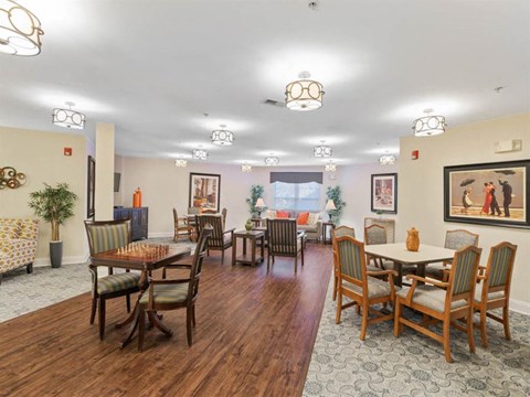 A dining room with a wooden table surrounded by chairs.