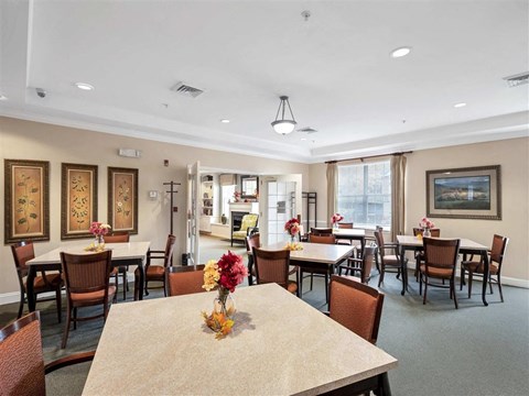 a dining room with tables and chairs and a kitchen