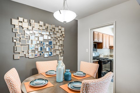 A dining room with a table set for four.