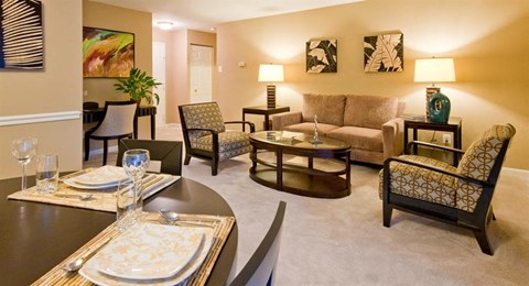 a living room and dining room with a table and chairs