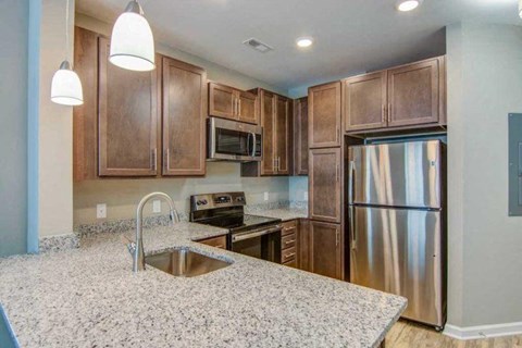 a kitchen with a sink and a stainless steel refrigerator