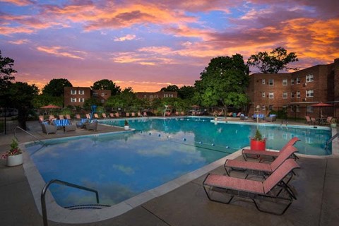 A pool with a sunset in the background.