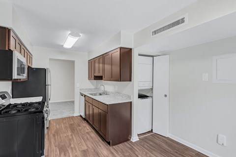 A kitchen with brown cabinets and a black stove top oven.