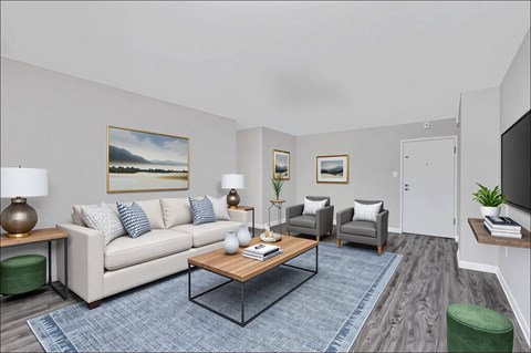 A living room with a white couch, a coffee table, and a painting on the wall.