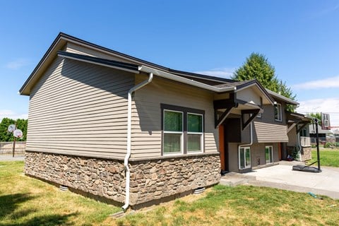 a house with a stone wall on the side of it