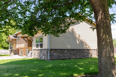 a house with a stone facade and a tree