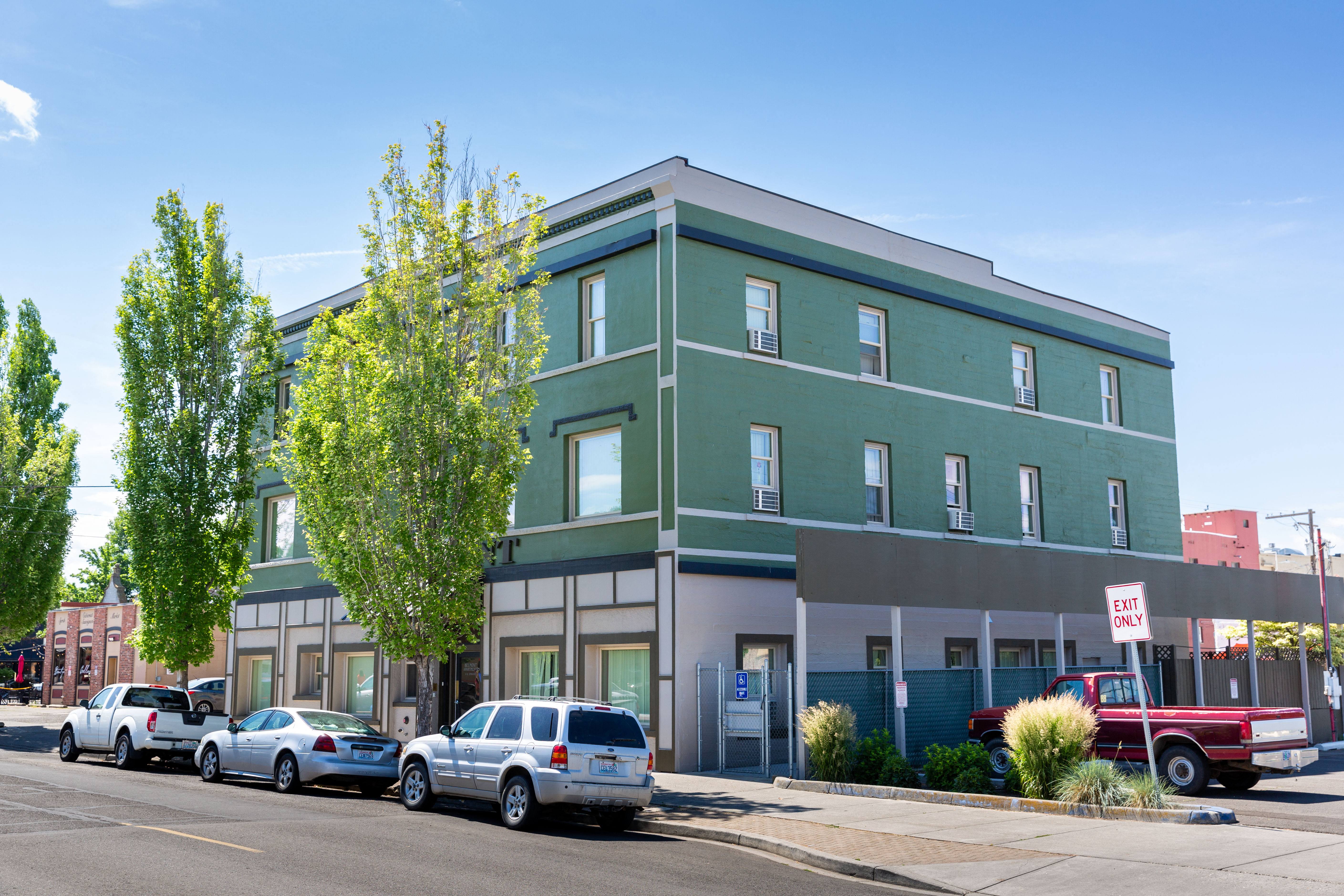 a green building with cars parked in front of it